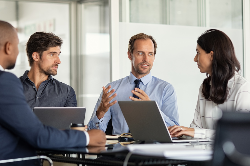 A Managed IT Services provider giving some new ideas about a project to his clients in a conference room. 