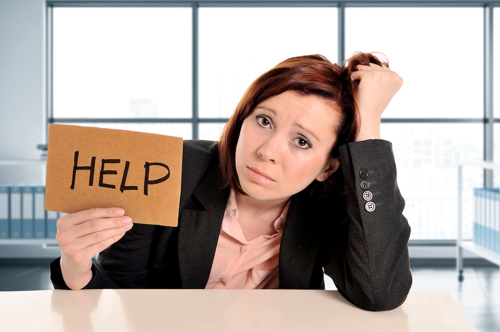 Frustrated office employee with help sign.