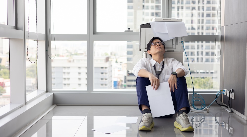 A frustrated man experiencing some printer problems.