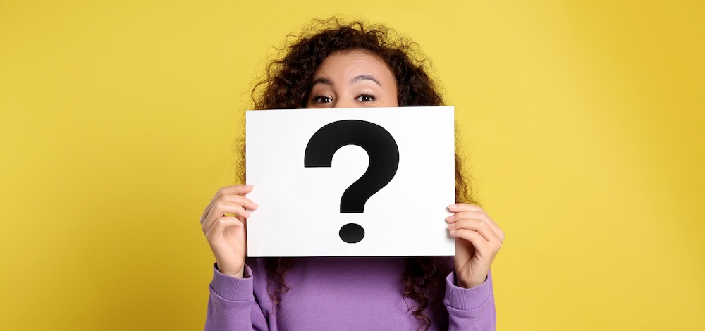 woman with question mark sign on yellow background